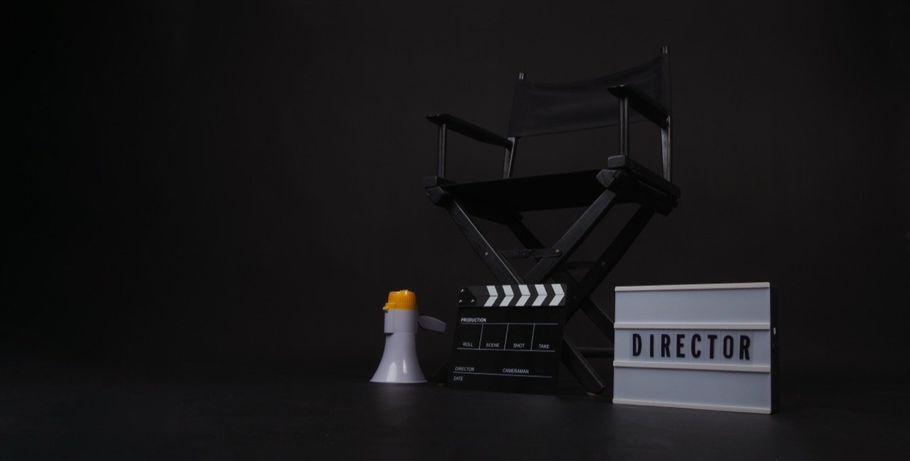 A director’s chair with a clapperboard, megaphone and Director lightbox.